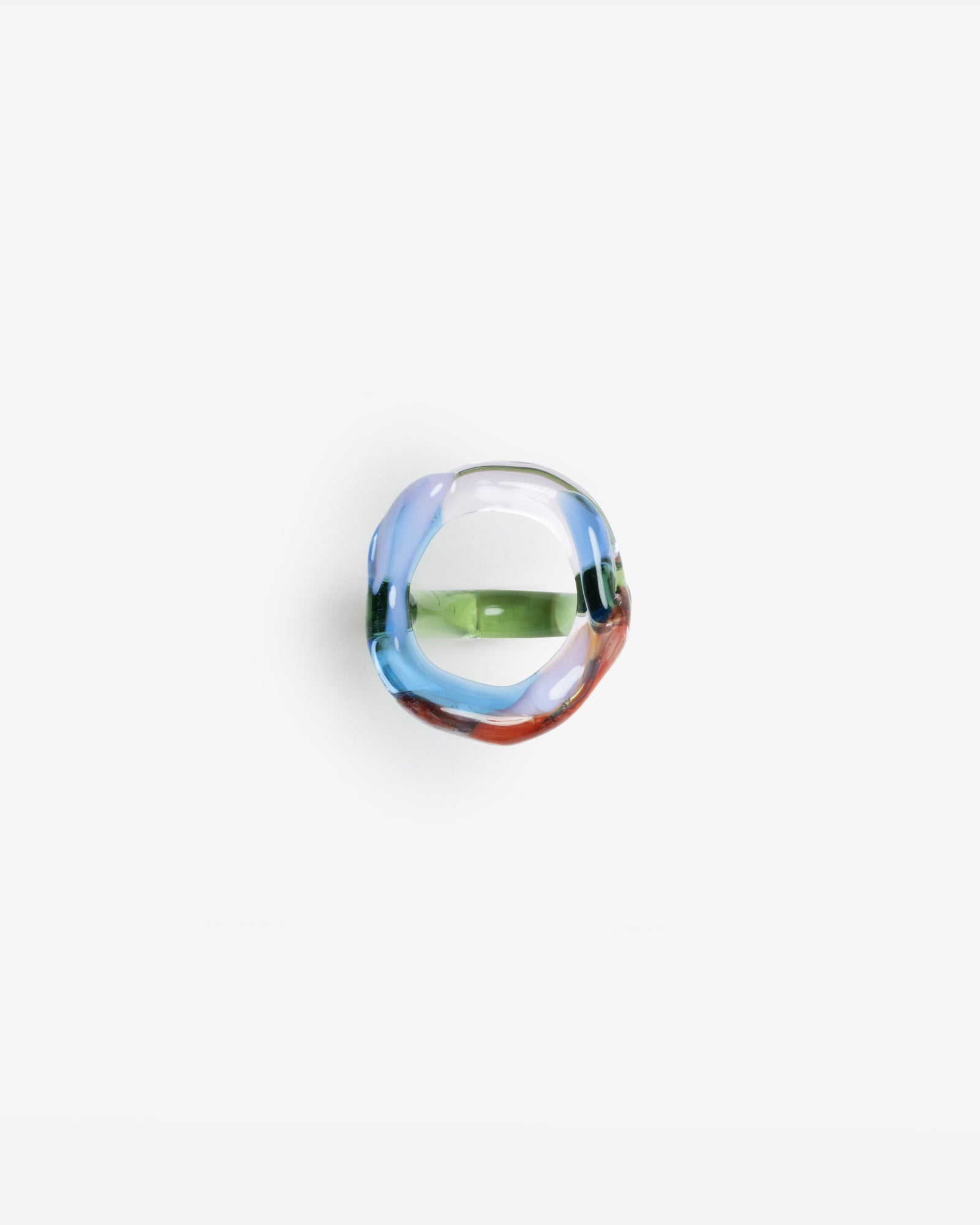 Garabato ring handcrafted from borosilicate glass featuring rainbow colors of blue, green, and red in an abstract, organic shape against white background, showcasing unique glass-blown artistry from Barcelona